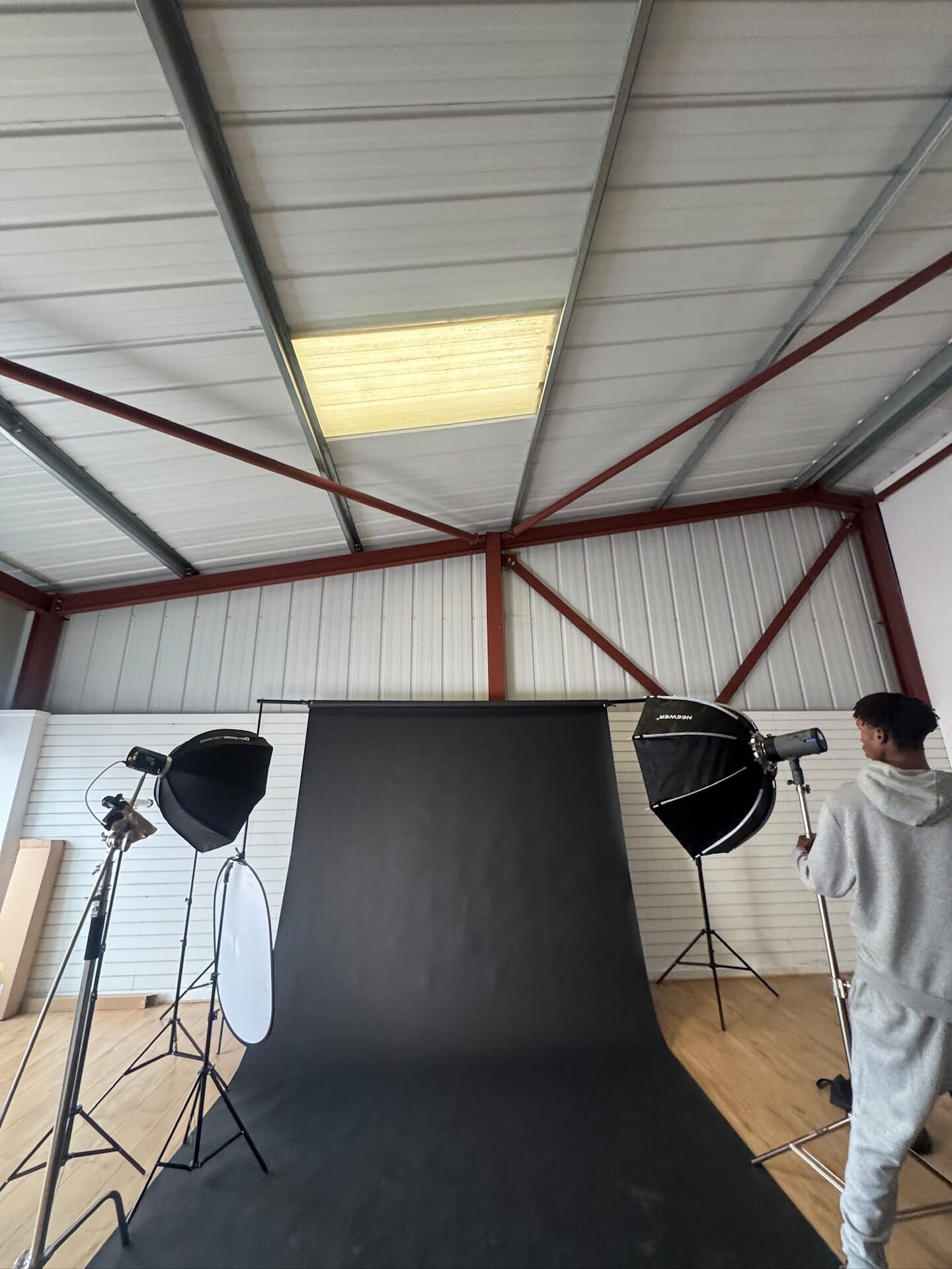 Black paper backdrop between two octagonal softboxes while a crew member adjusts a light